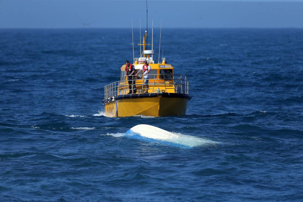 The coastguard approaches the upturned vessel where two men drowned this morning. Picture: Rob Gunstone
