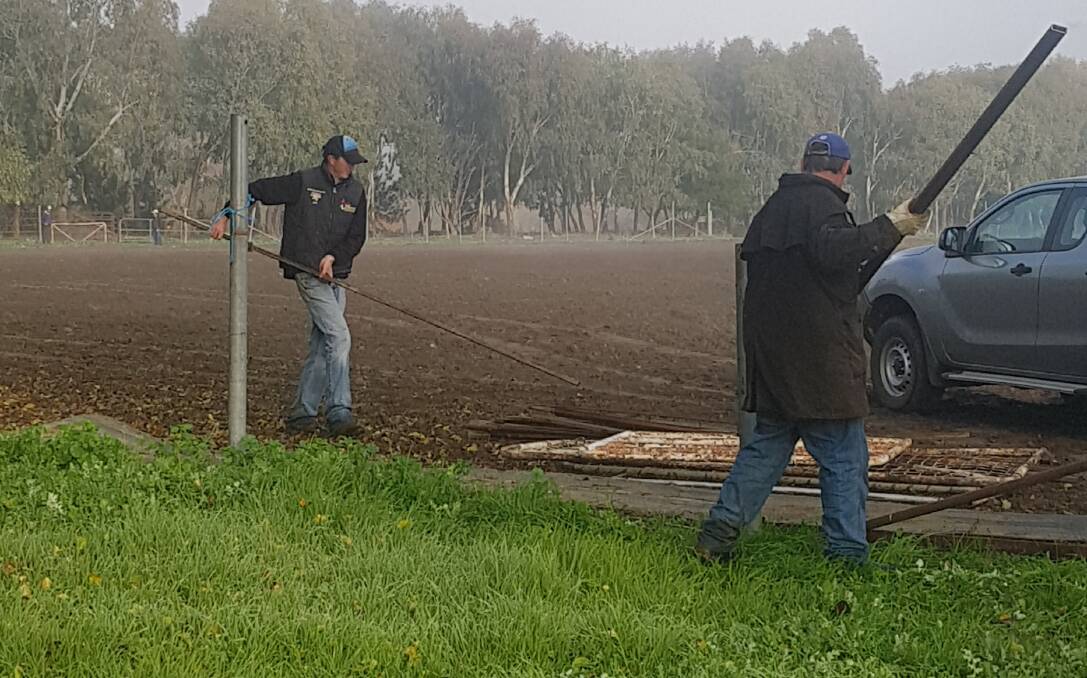 BUSY: Workers remove the old fencing at Gundagai in preparation for the rodeo club's new campdraft arena. Picture: Supplied.