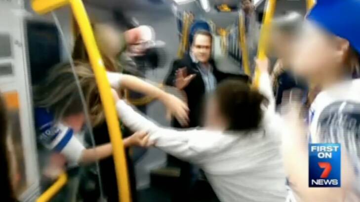 A male passenger tries to stop a brawl between teenage girls on a Sydney train. Photo: Seven News