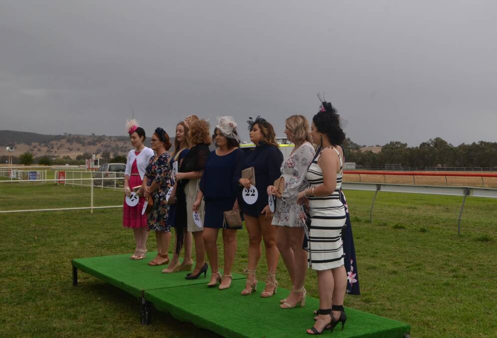 Against a background of overcast sky, young ladies lined up for the  Fashions of the Field at Holbrook Races.