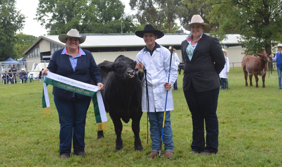 RESERVE: Judge Renae Keith, Allenae Angus and Poll Herefords, Roslyn, with reserve champion school parader Jack of St John's College, Dubbo, and associate judge Emily Polsen, Grace Valley Livestock, Yass. 