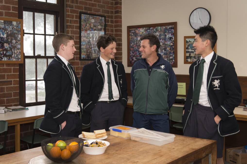 COMMUNITY: Geelong College students (from left) Nick Delaney, Angelo Binos and Jason Chen with head of boys boarding Gareth Gilby.