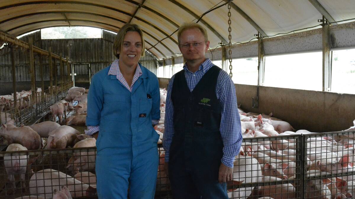 Edwina Beveridge, Blantyre Farms, Young, with Australia's Chief Veterinary Officer, Dr Mark Schipp, in a shed filled with young grower pigs. The pigs are fed a liquid diet.   