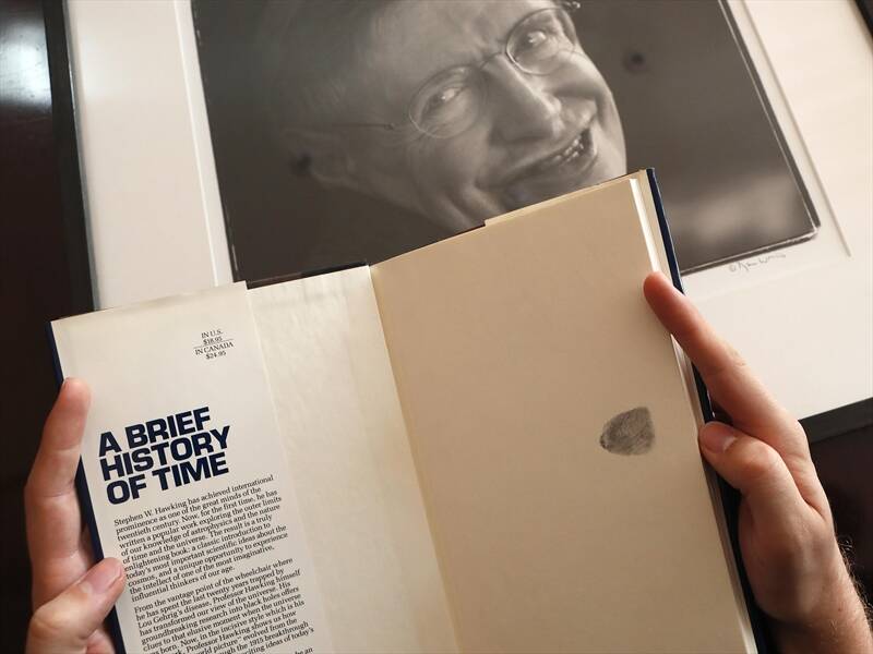 A copy of Stephen Hawking's book with his thumbprint autograph is among items being auctioned.