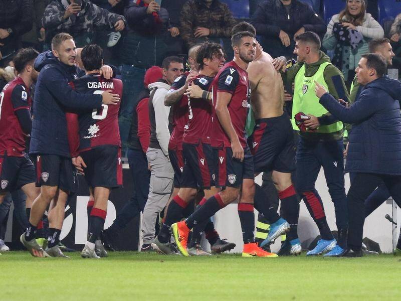 Cagliari players and fans celebrate the match-winning goal against Sampdoria in Sardinia.