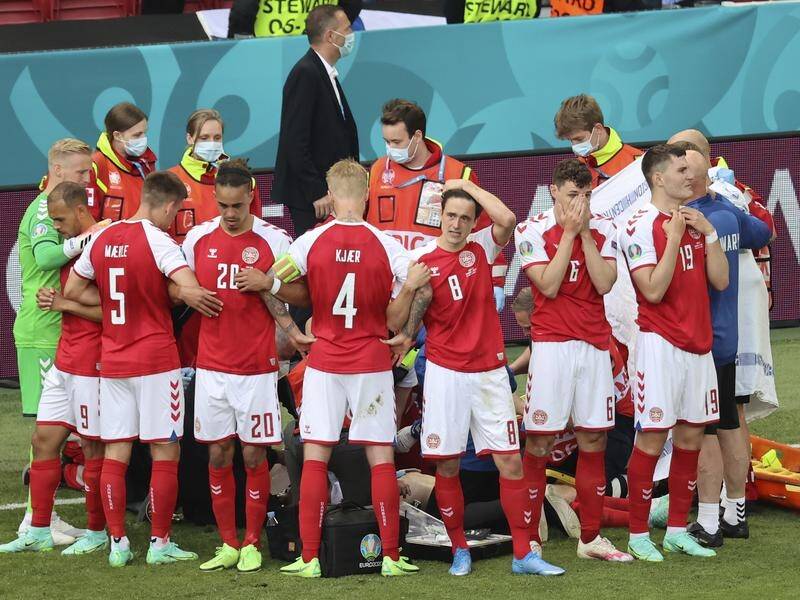 Denmark players surround the stricken Christian Eriksen in Copenhagen.
